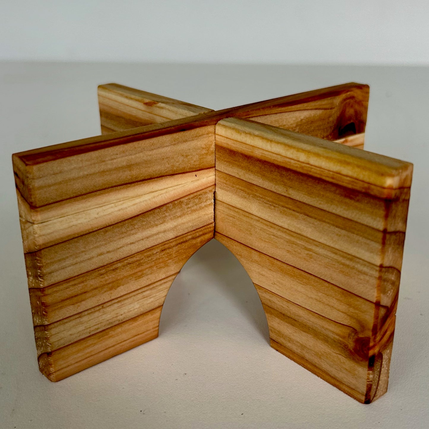 LB X-Configuration: A 6-inch statement scale interlocking red cedar plant stand. A structural wood foundation and tectonic anchor designed to elevate artifacts within the manufactured environment.